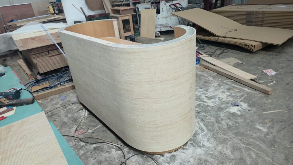 detail meja resepsionis custom dengan tampilan travertine dan LED